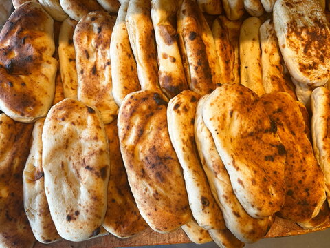 Nan-e Barbar. Fresh tradition iraqian bread sold at local farmers market. Panuozzo Italian sandwich of pizza bread