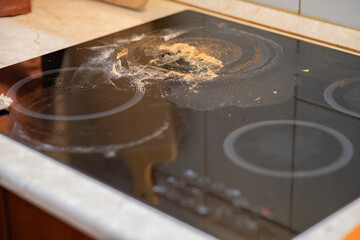 Dirty glass-ceramic stovetop with burnt residue
