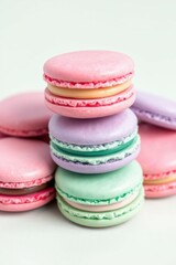 Fototapeta premium Colorful stacked macarons: a delightful confectionery tower of pastel hues against a clean, bright backdrop.