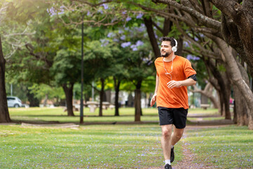 Hombre entrenando y corriendo en un parque urbano en un hermoso día soleado. Hombre corriendo...