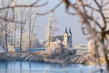 Von B&auml;umen und &Auml;sten eingerahmte Kirche im Winter