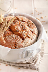 Fresh round loaf bread baked in a rustic bright kitchen.