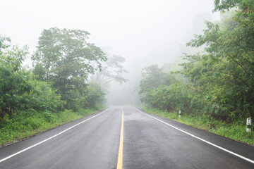 Fototapeta premium Wet asphalt road with beautiful view of misty landscape, Road background.