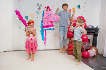 Girl in princess outfit tries to hit unicorn pinata blindfolded