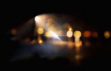 A bright, white light shines through a thin, orange ring in a dark background.