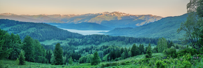 Mountain landscape at sunset, mountain taiga, fog in the valley, panoramic view