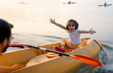 A happy toddler kayaking on a serene pond