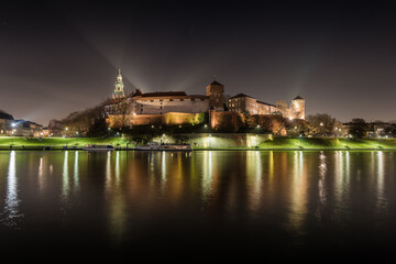 Obraz premium Poland, Krakow: Royal Castle of Wawel by night with reflection in Vistula River