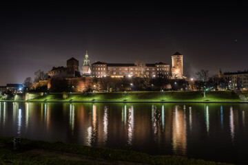 Fototapeta premium Poland, Krakow: Royal Castle of Wawel by night with reflection in Vistula River