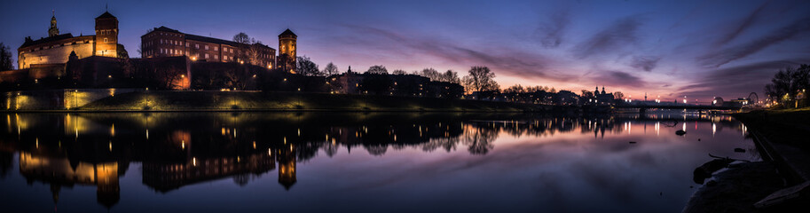 Poland, Krakow: Royal Castle of Wawel by morning blue hour with reflection in water