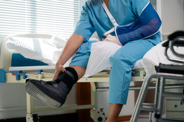 Young patient recovering in hospital bed, wearing blue arm sling and walking boot, healing process...