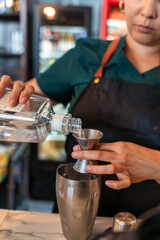 A Bartender Skillfully Preparing an Exquisite Cocktail with Precision in a Trendy Bar Scene