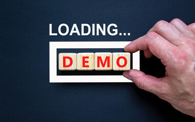 Demo symbol. Concept word Loading Demo on beautiful wooden blocks. Businessman hand. Beautiful...