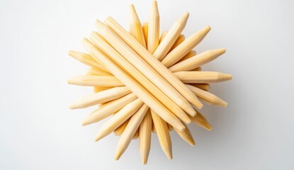 Overhead shot of light beige, slender, pointed objects arranged in a radial pattern on a white background. The objects are tightly clustered