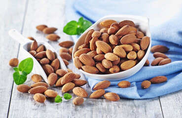 Migdały w niewielkiej miseczce na tle niebieskiego materiału