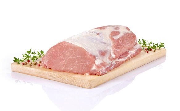 Surowy schab wieprzowy ze świeżymi ziołami i kolorowym pieprzem na drewnianej desce