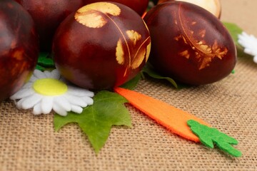 Easter bunny on a beautiful spring meadow with dandelions in front of a basket with Easter eggs