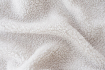 Macro shot of sustainable sherpa fleece textile in white color.  © Valeriia