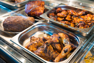 Grilled chicken drumsticks and wings in a buffet display