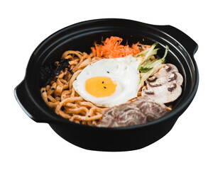 An egg fried on top of masroom carrot salad in a black steel ball