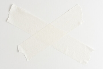 White masking tape in form of cross on white background with place for copying text.