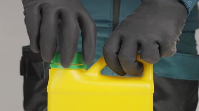 A man in black gloves pours bleach into a container, raising suspicions. Creative