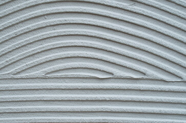 Gray decorative relief plaster on wall closeup