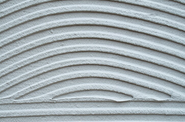 Gray decorative relief plaster on wall closeup