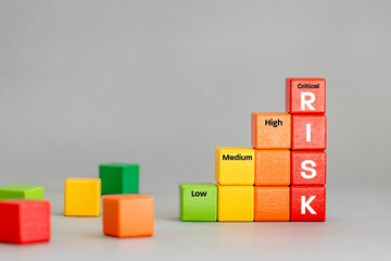 Growing risk. blocks in colors of increasing threat. Word RISK on red cubes. Business concept. Gray backgroundcopy space