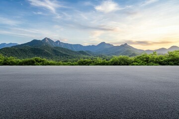 Scenic mountain view with an open road, lush green forests, and a bright cloudy sky