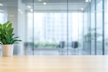 Plant on a desk in a bright office space with glass walls and a blurred background view