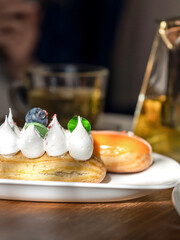 Plate of pastries with a blueberry on top and a white frosting