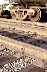 Loose spike found on railroad track, with rail car in background.