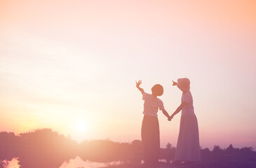 a silhouette of a happy young girl child the arms of his loving