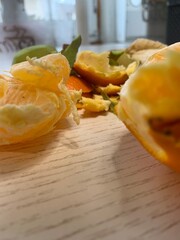 Citrus peels are scattered on a light wooden surface. The bright indoor area shows soft natural light filtering through the windows, creating an inviting atmosphere