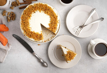 Top view of homemade carrot cake made with walnuts, iced with cream cheese. The Cut piece lies on the plate. White background. carrot cake day