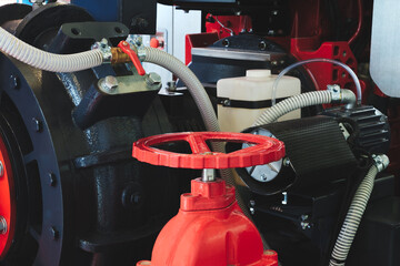 A red valve is attached to a machine. The valve is red and has a silver knob  industrial concept...