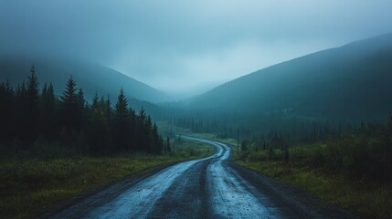 A winding road leads into a dense foggy mountain landscape
