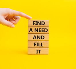 Naklejka premium Fill the need symbol. Concept word Find a Need and Fill it on wooden blocks. Businessman hand. Beautiful yellow background. Business and Fill the need concept. Copy space