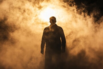 Obraz premium Silhouette of a man in clouds of thick smoke or fog.