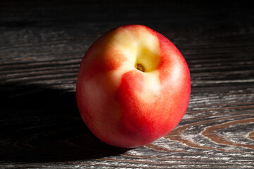 white nectarine on black wood background