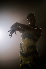 Latina dancer in a stunning yellow dress performs bachata in the dark, surrounded by swirling smoke...