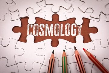 Cosmology. White puzzle pieces and colored pencils