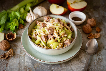 Salad with celery, meat and apple in a nice plate for lunch. Salad with pork and vegetables for dinner. on a gray background. Close-up