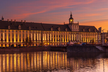 Zachód słońca w mieście - Wrocław zachód słońca z widokiem na rzekę Odrę, budynki i niebo. © Tomasz