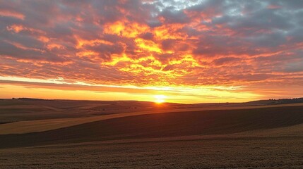 Fototapeta na wymiar Vibrant Sunset Over Open Land with Golden Light Breaking Through