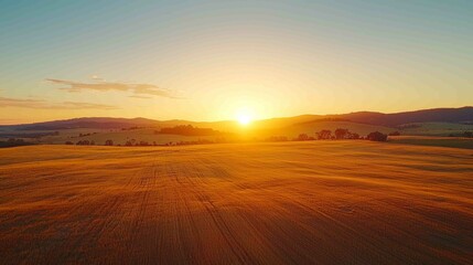 Obraz premium Vibrant Sunset Over Open Land with Golden Light and Soft Hues