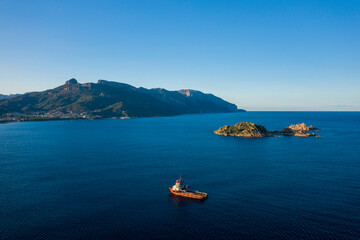 Boats in front of the Isola dell Ogliastra islands in Lotzorai in Europe, Italy, Sardinia, Lotzorai, in summer, on a sunny day.