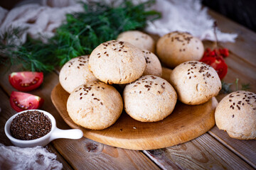 Small rye rolls on a wooden table for lunch. Delicious buns for dinner. Close-up