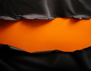 torn black material exposing bright orange background